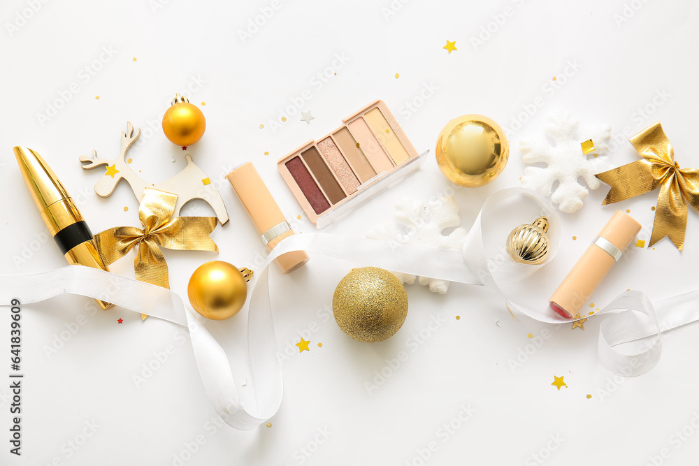 Composition with decorative cosmetics and golden Christmas decor on white background