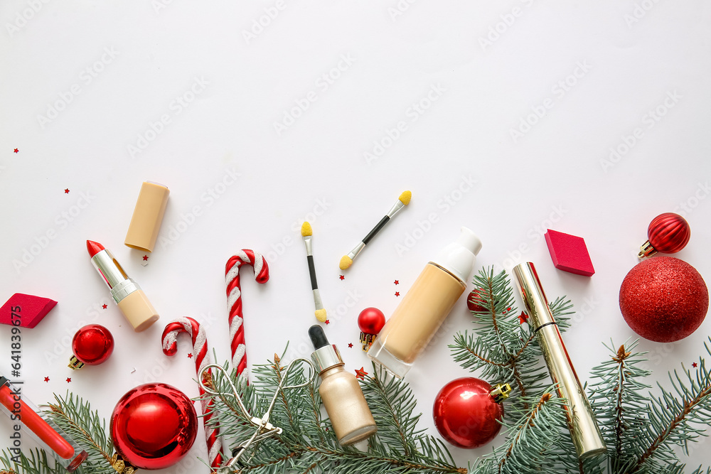 Decorative cosmetics with fir tree branches and red Christmas decor on white background