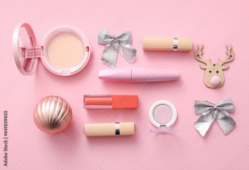 Composition with decorative cosmetics and Christmas decor on pink background