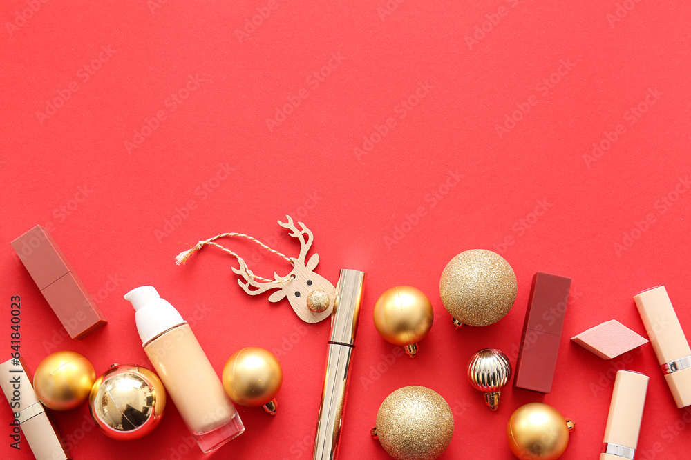 Composition with makeup products and golden Christmas balls on red background