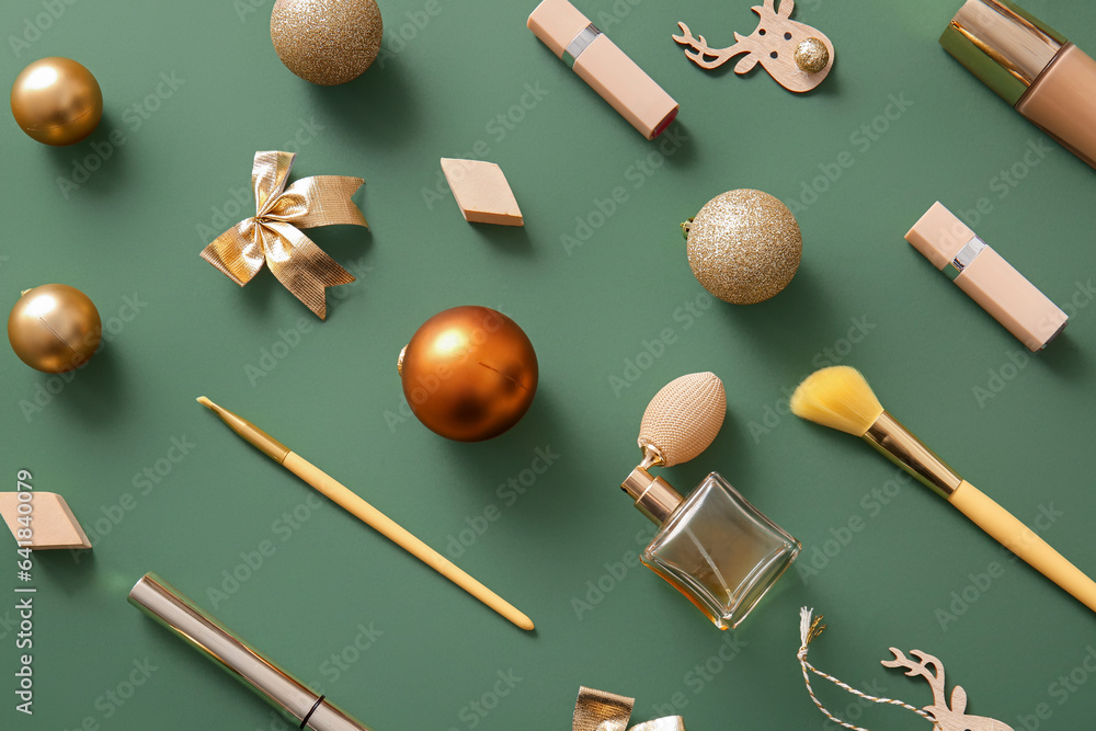 Composition with makeup products and golden Christmas decor on dark green background