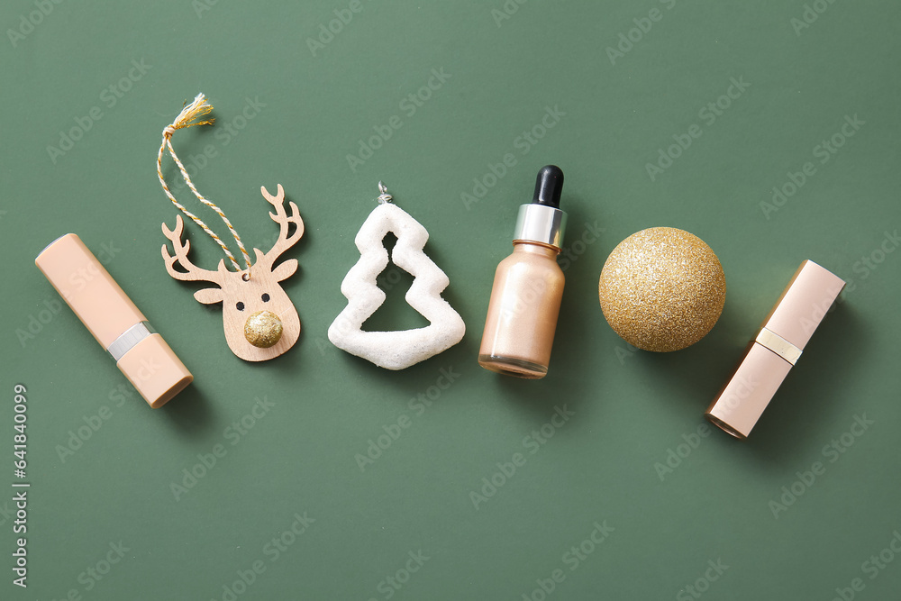 Composition with makeup products and Christmas decor on dark green background