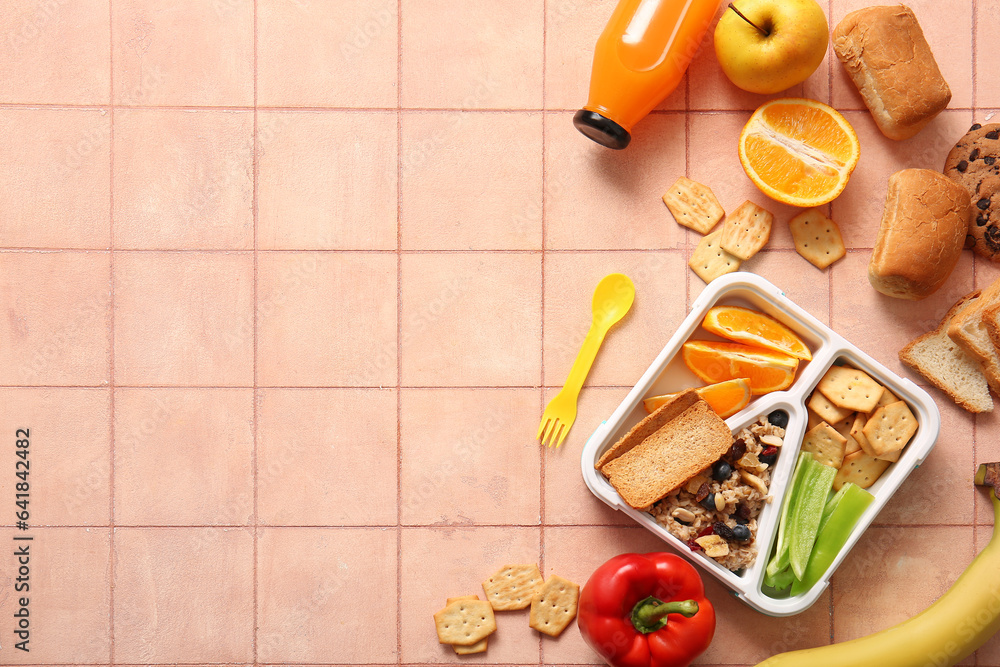 Lunchbox with delicious food and bottle of juice on orange tile background