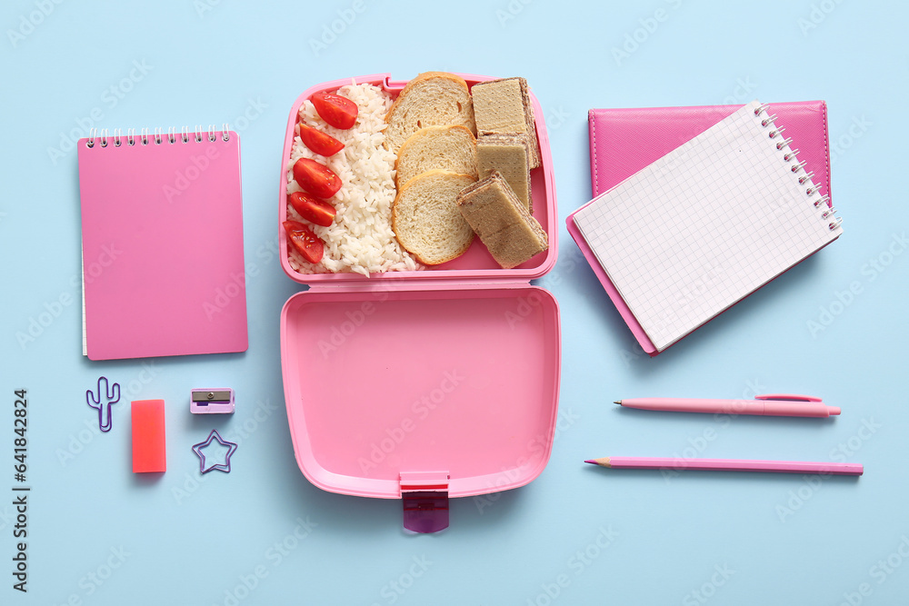 Lunchbox with delicious food and different stationery on blue background