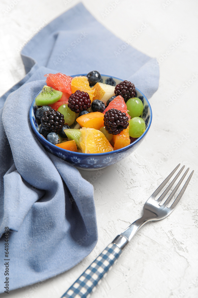 Bowl of fresh fruit salad on light background