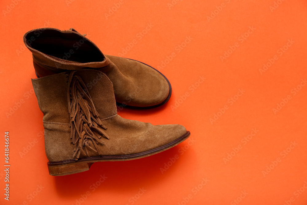 Pair of childs leather boots on color background