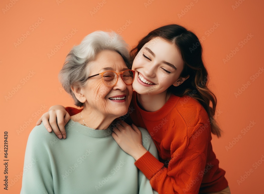 A young lady embraces her grandmother while smiling