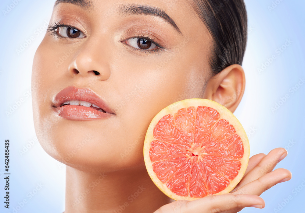 Portrait, skincare and grapefruit with a natural woman in studio on a blue background for health or 