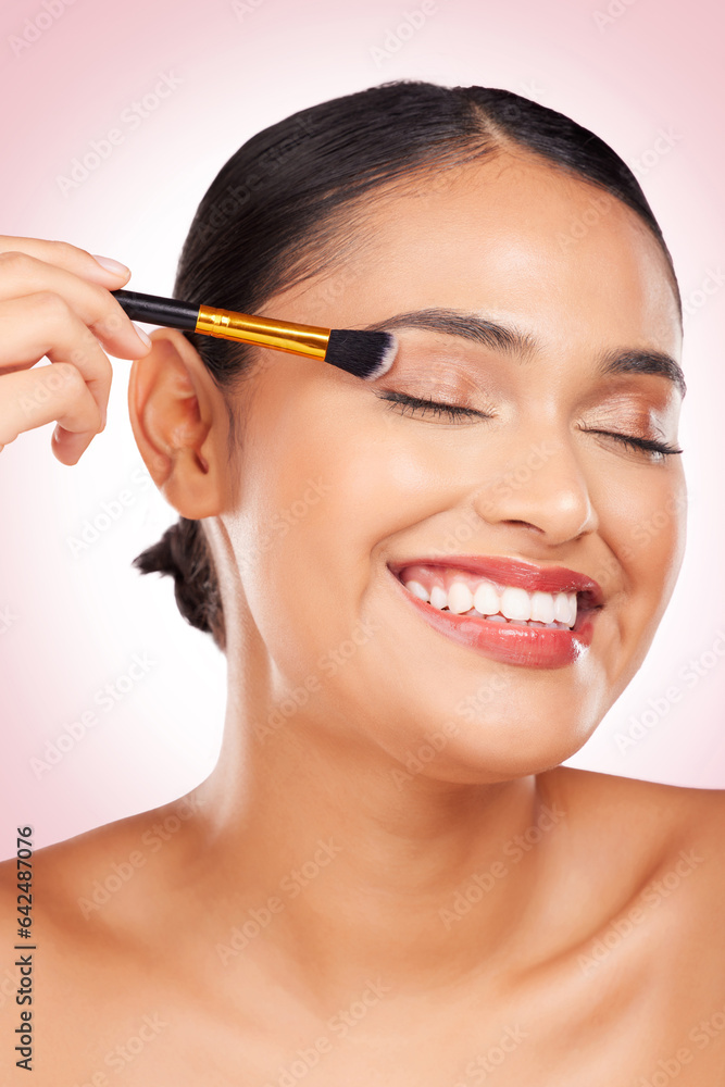 Happy, eyeshadow and a woman with a brush on a pink background for skincare, wellness and health. Sm