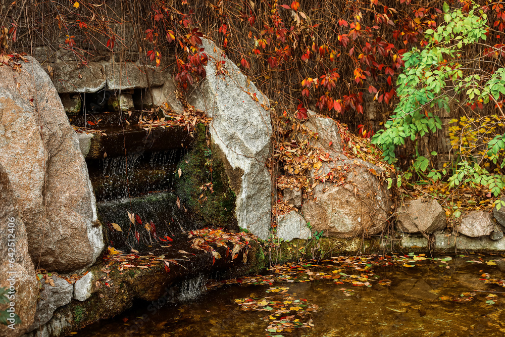 View of beautiful waterfall in autumn park