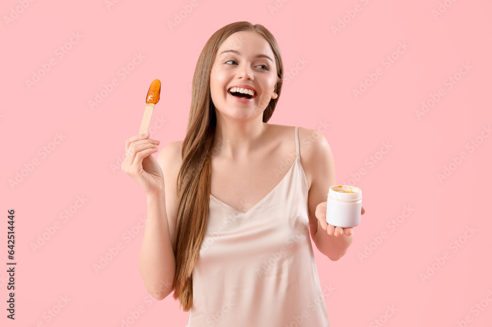 Pretty young woman with sugaring paste on pink background