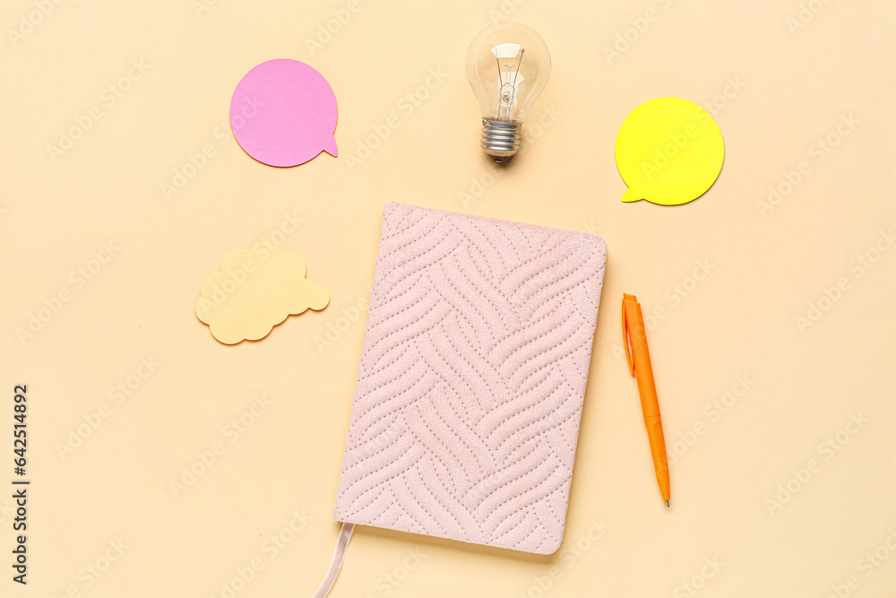 Notebook with light bulb and speech bubbles on beige background. Logic concept