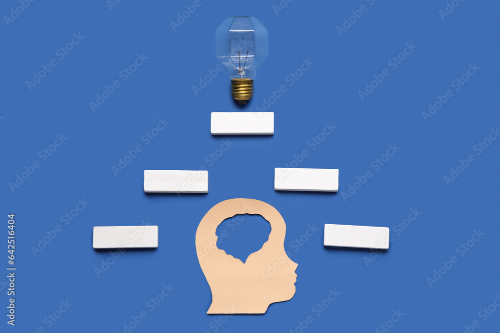 Paper human head with blocks and light bulb on blue background. Logic concept