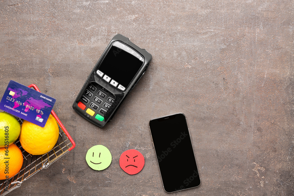 Rating smiles, shopping cart with fruits, payment terminal and mobile phone on dark background. Cust