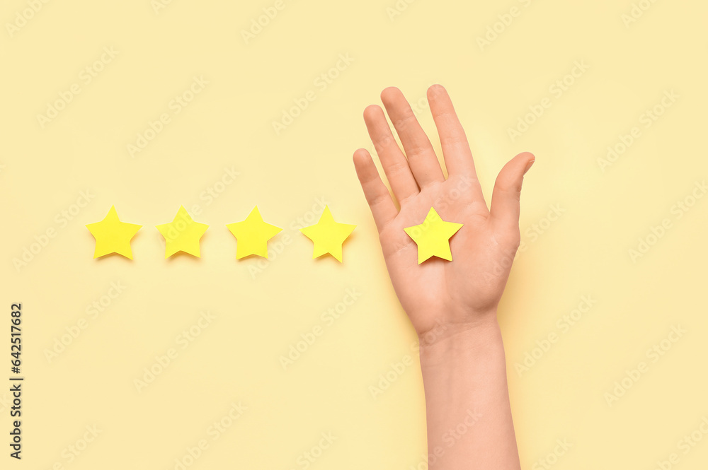 Female hand and five stars on color background. Customer experience concept