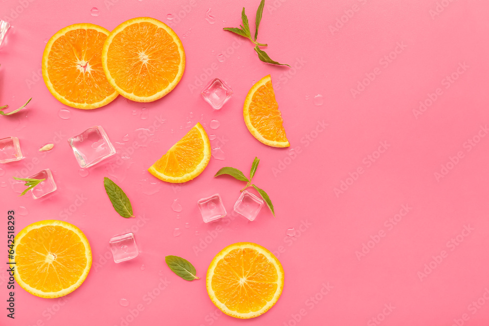 Orange slices with water drops, mint and ice cubes on pink background