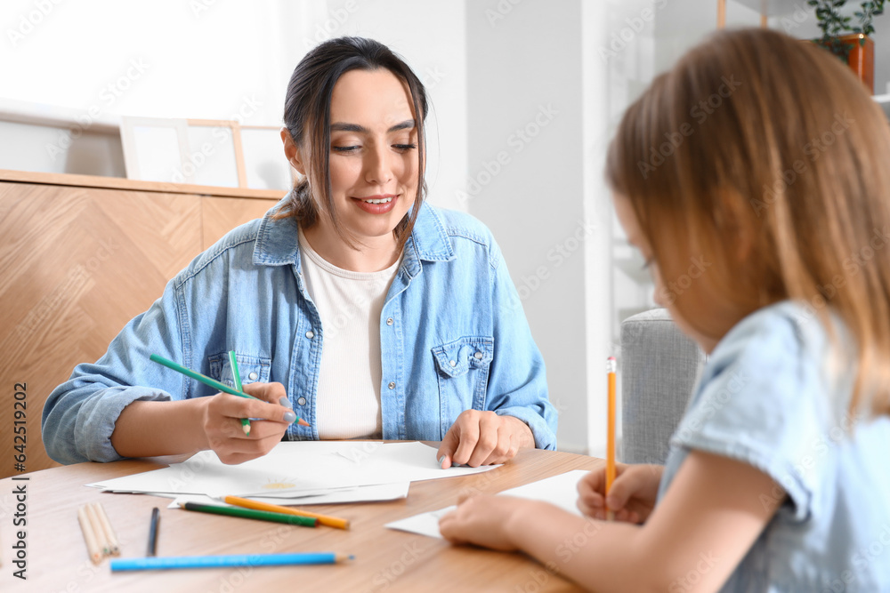 Young woman with her little daughter drawing at home