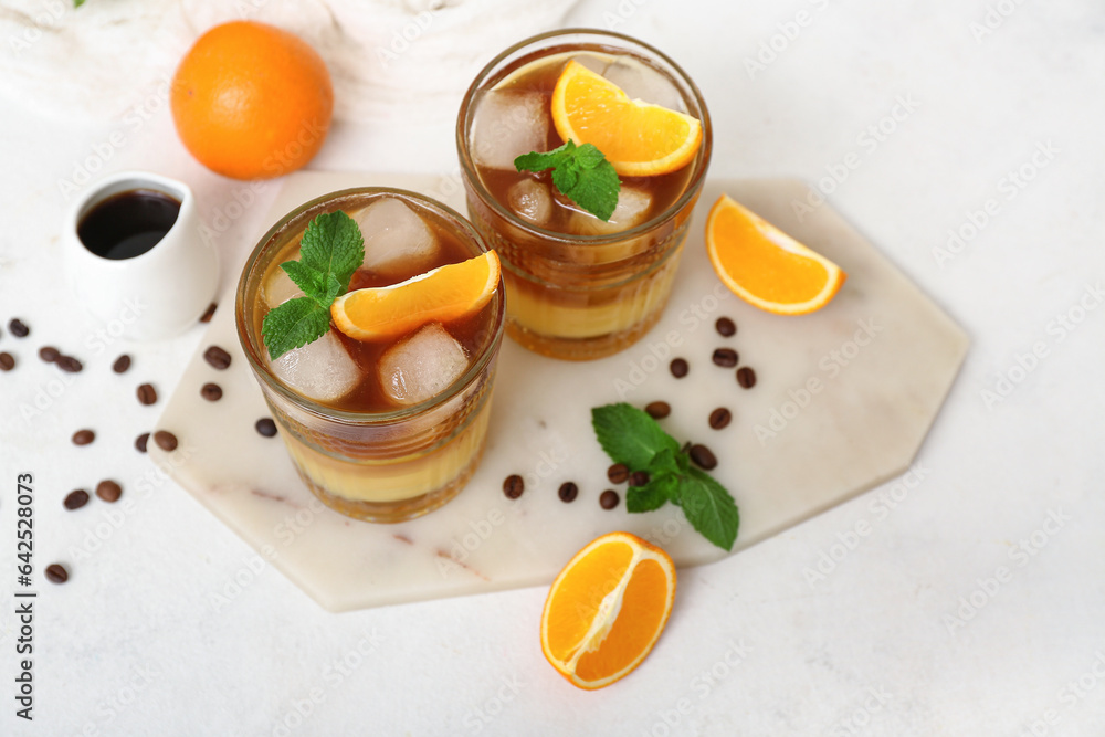 Glasses of tasty orange espresso on light background