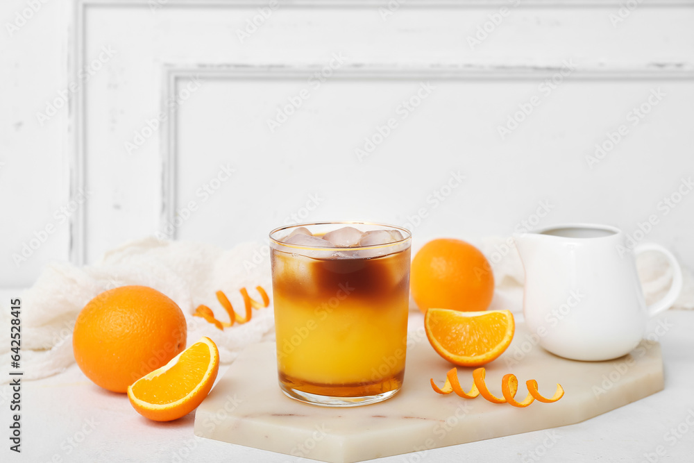 Glass of tasty orange espresso on white table