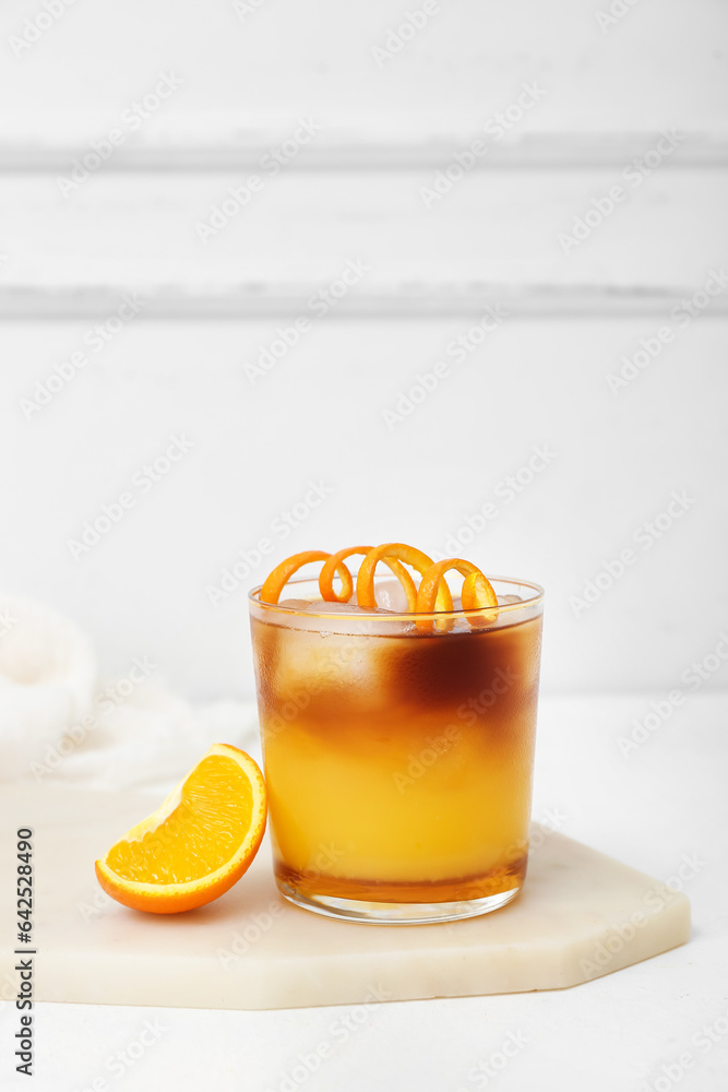 Glass of tasty orange espresso on white table