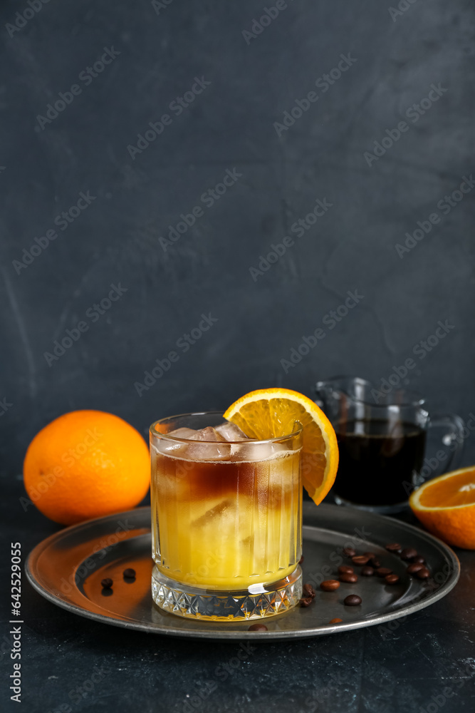 Glass of cold orange espresso on black background