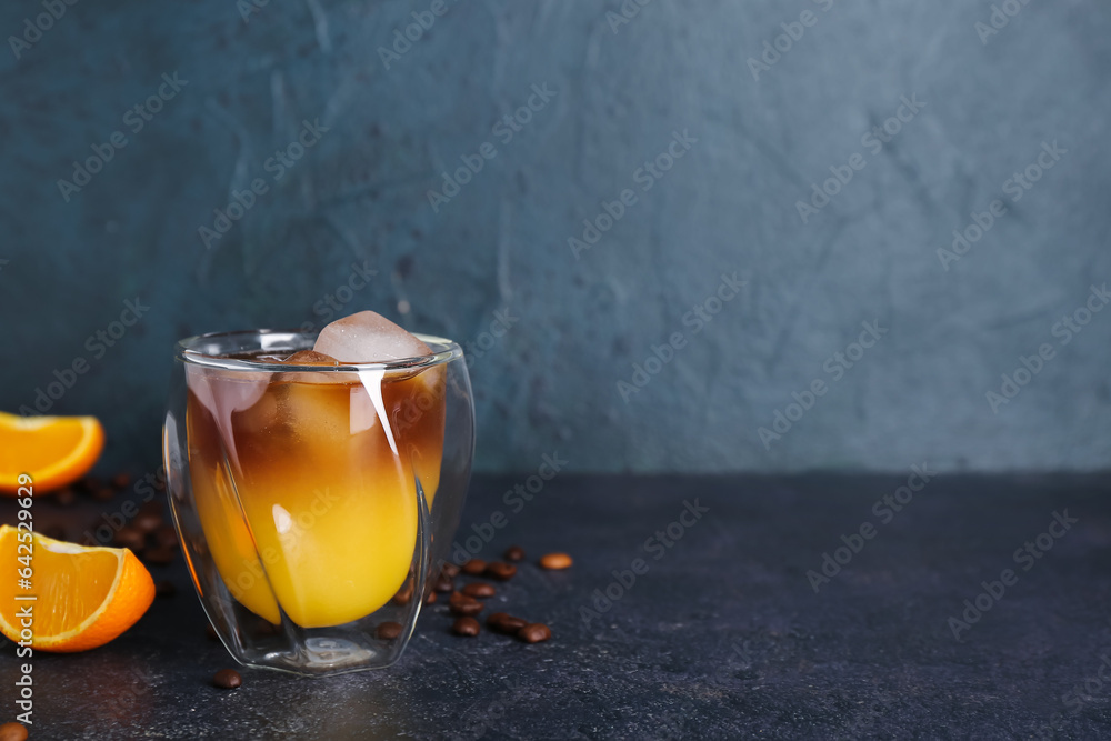 Glass of cold orange espresso on dark blue background