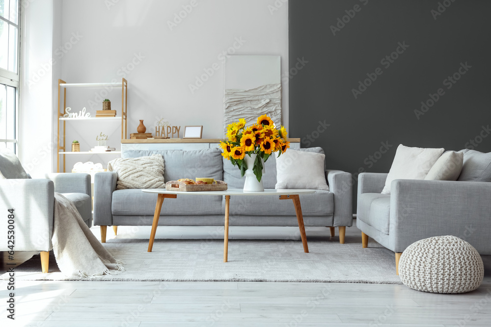 Interior of living room with sunflowers in vase and breakfast on table