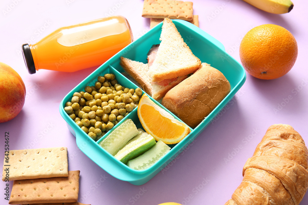 Lunchbox with delicious food and bottle of juice on lilac background