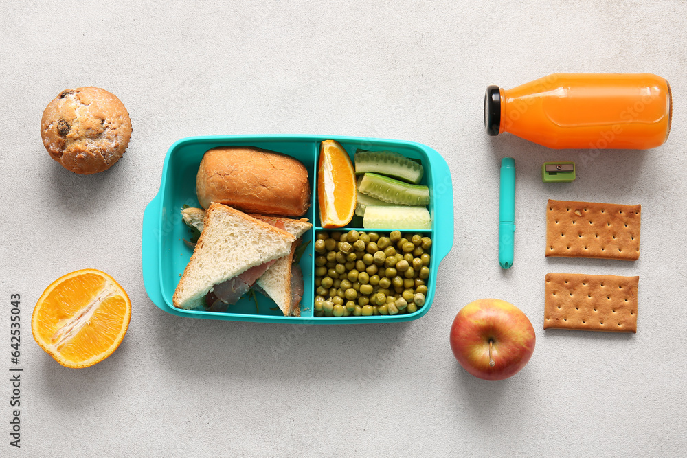 Lunchbox with delicious food and bottle of juice on light background