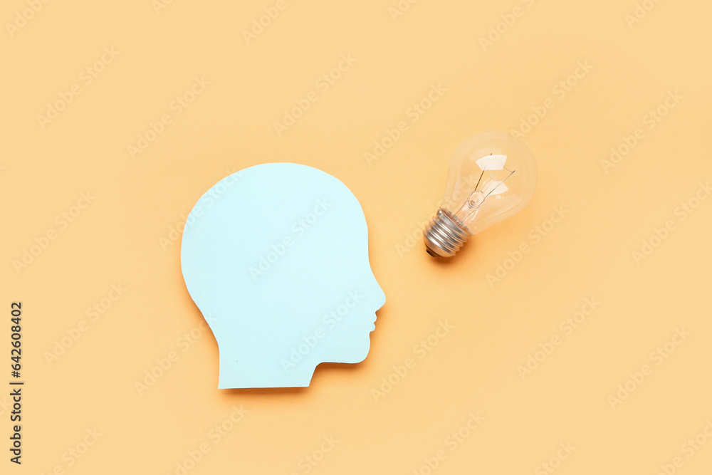 Paper human head with light bulb on color background. Logic concept