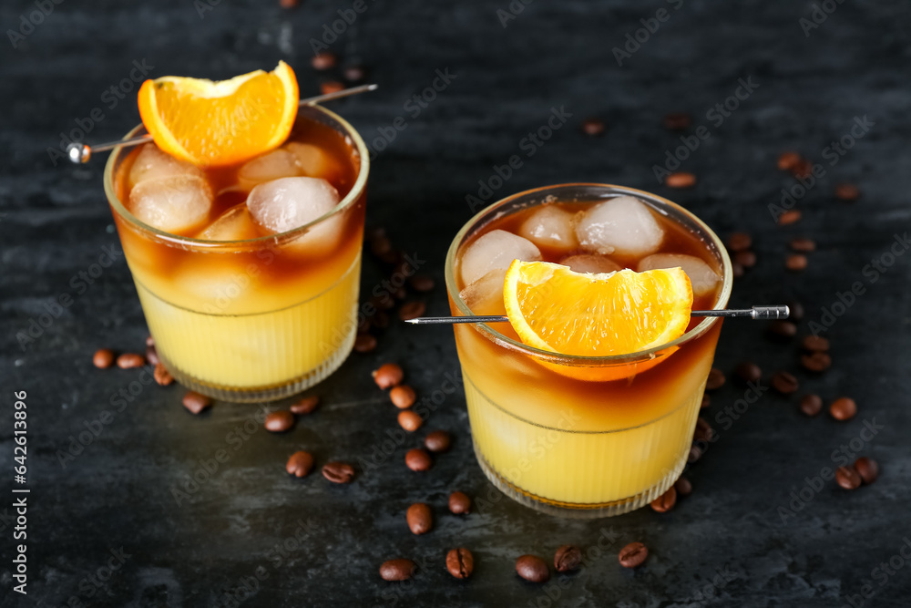 Glasses of cold orange espresso on black background