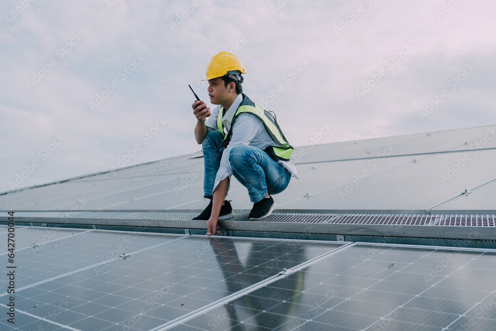 Engineers wearing a uniform walking on roof inspect and check solar cell panel, solar cell is smart 