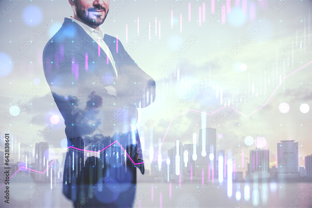 Young european businessman with folded arms standing on blurry city background with forex chart. Suc