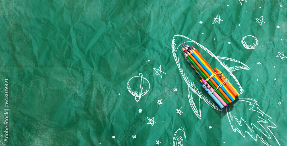 Back to school theme with hand drawn rocket and colored pencils - crumpled paper background