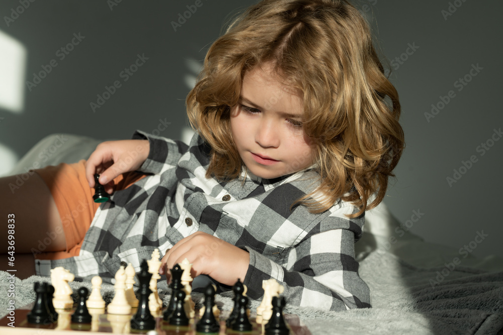 Clever thinking child. Child think about chess game. Intelligent, smart and clever school kid pupil.