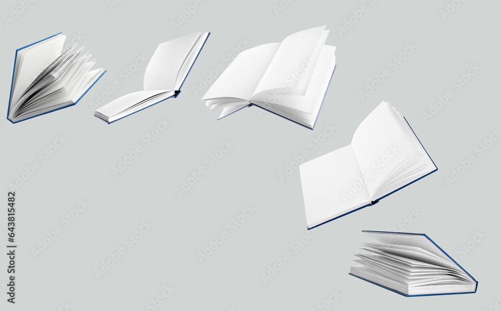 Many flying books on grey background