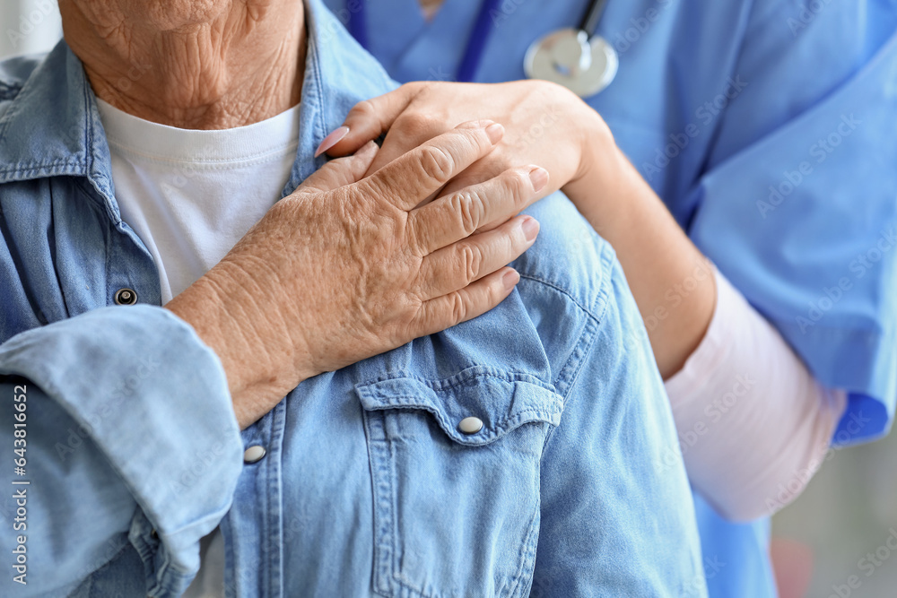 Senior woman hugging with caregiver, closeup