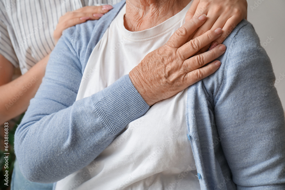 Young woman with her grandmother hugging at home, closeup