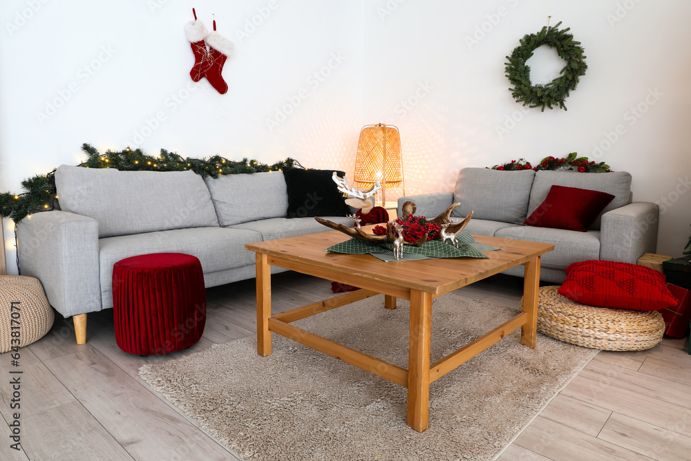 Interior of living room with grey sofas, coffee table and Christmas decor