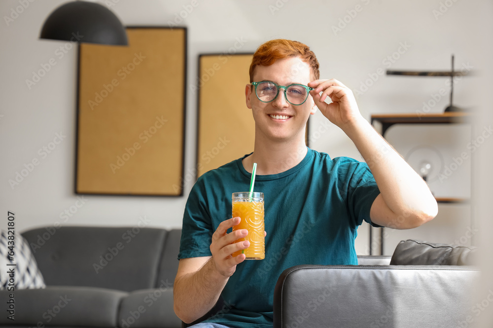 Young man with glass of juice at home