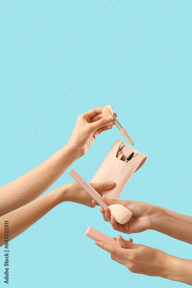 Women with makeup products on blue background