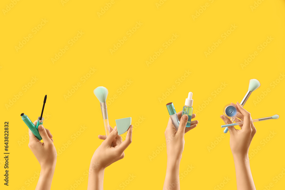 Women with makeup products on yellow background