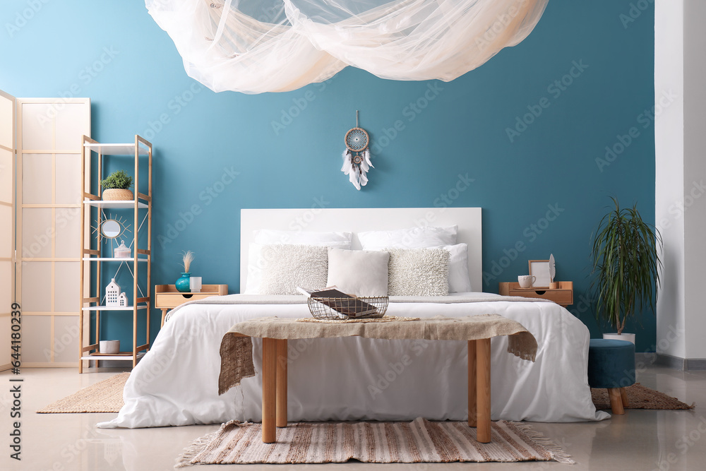 Interior of bedroom with dream catcher and bed