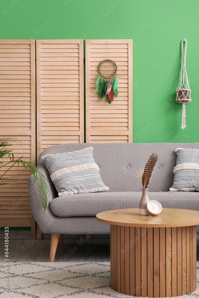 Interior of living room with sofa and dream catcher on folding screen