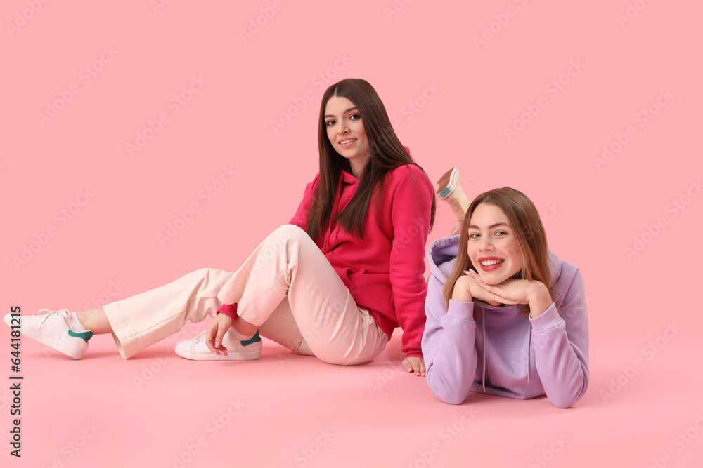 Female friends on pink background