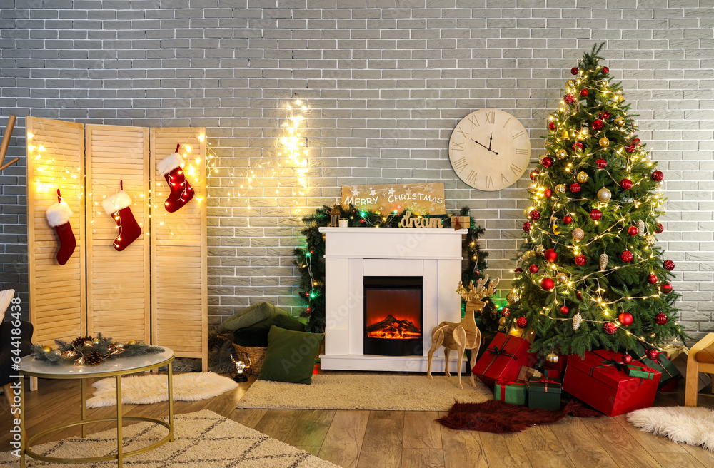 Interior of living room with Christmas tree, fireplace, gifts and folding screen