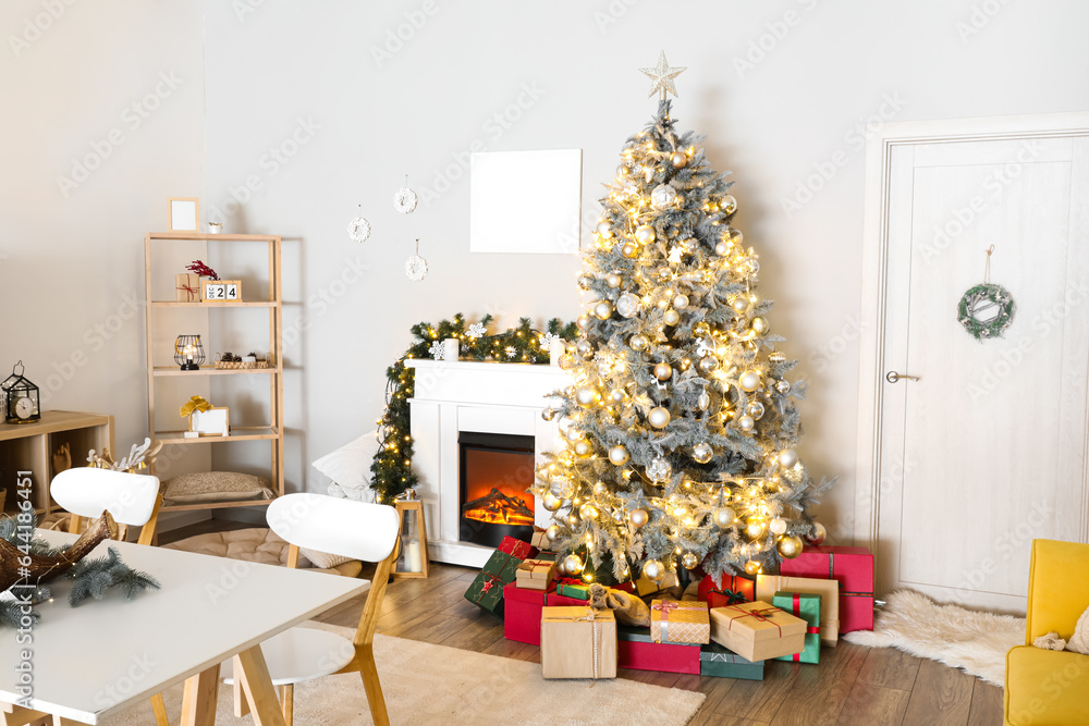 Christmas tree with glowing lights and gifts in interior of living room