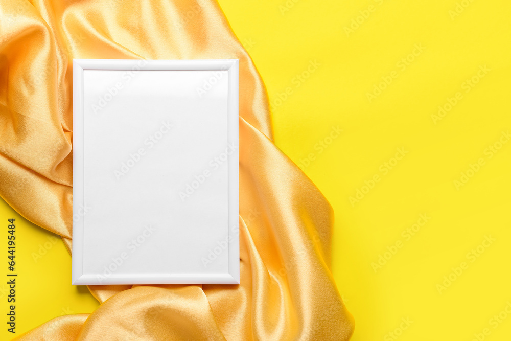 Blank picture frame with fabric on yellow background