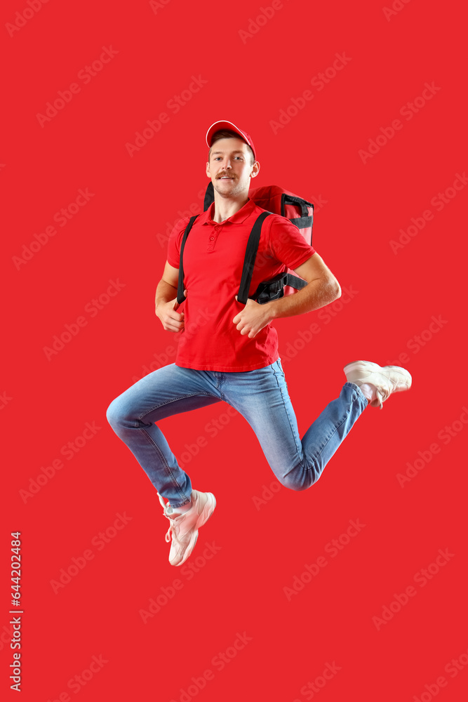 Jumping courier with bag on red background