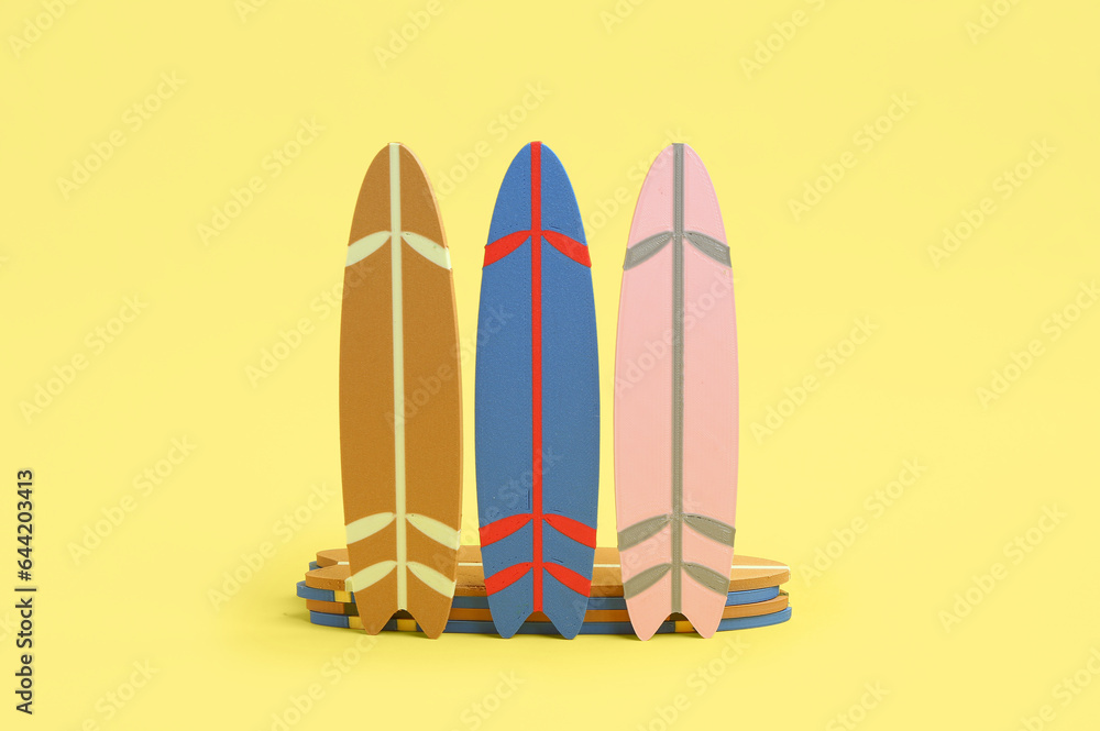 Different mini surfboards on yellow background